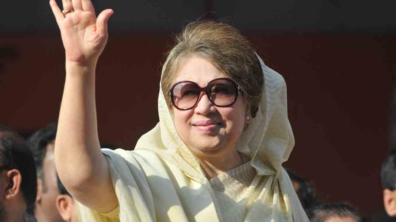 Khaleda Zia in a white shawl waves her hand 