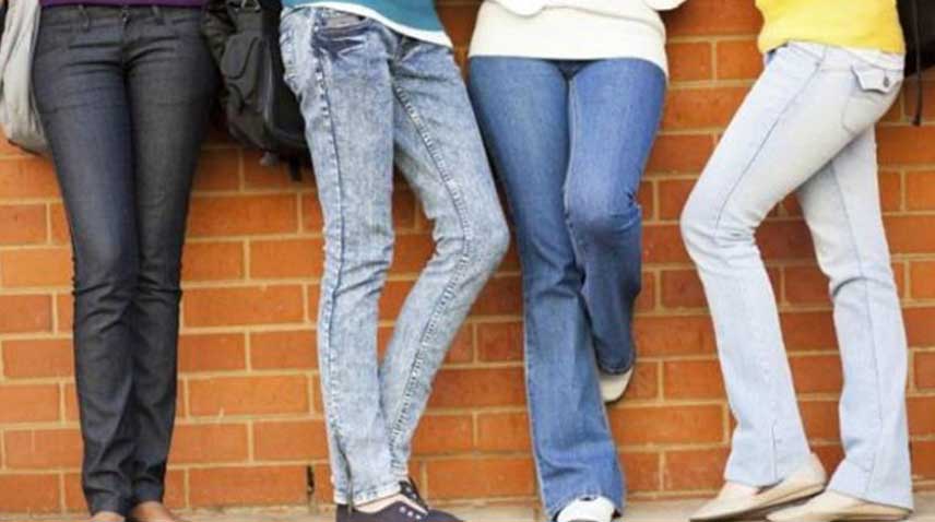 Girls stand wearing jeans.