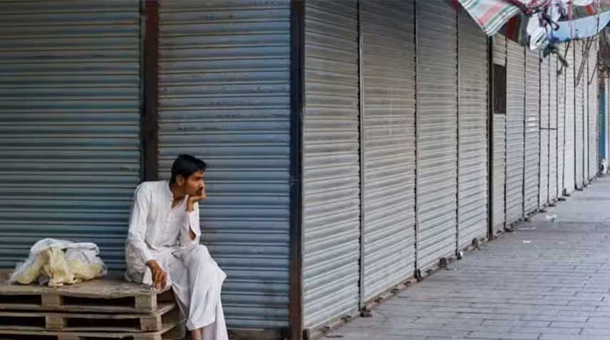 A man sits in a market closed due to a strike by traders.