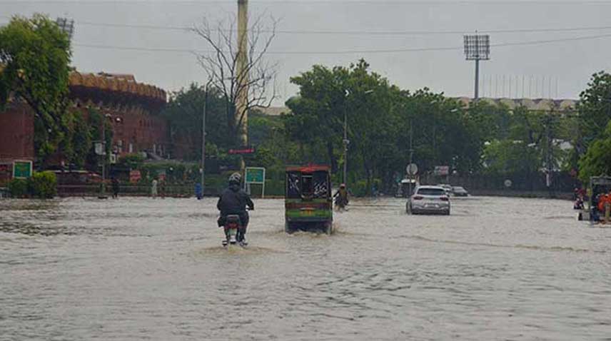 Motorists wade through rainwater in Lahore.