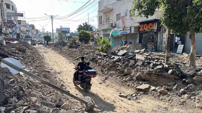 Palestinians ride a motorcycle on a damaged street following an Israeli military operation in Jenin in the Israeli-occupied West Bank.