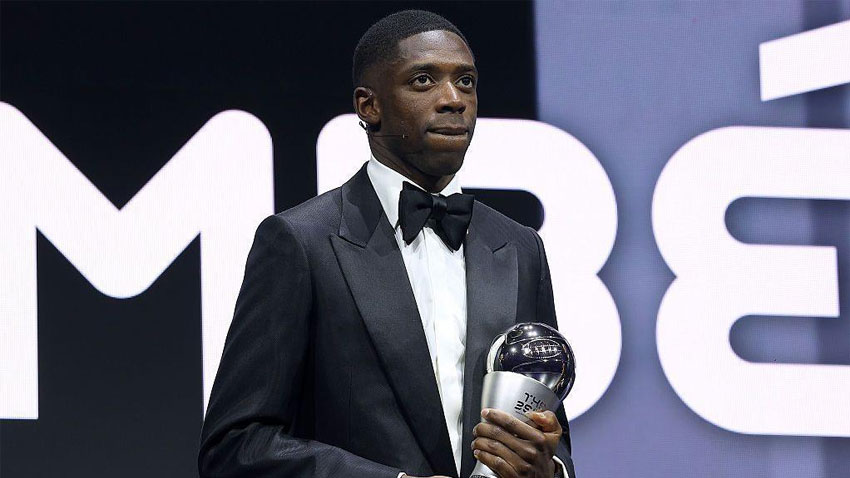 Ousmane Dembélé holding a trophy at an event. via BBC
