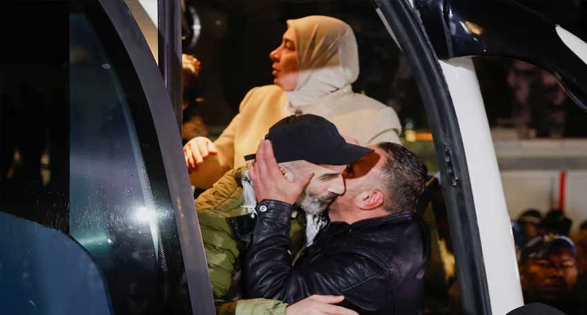  People embrace as Palestinian prisoners arrive on a bus - REUTERS