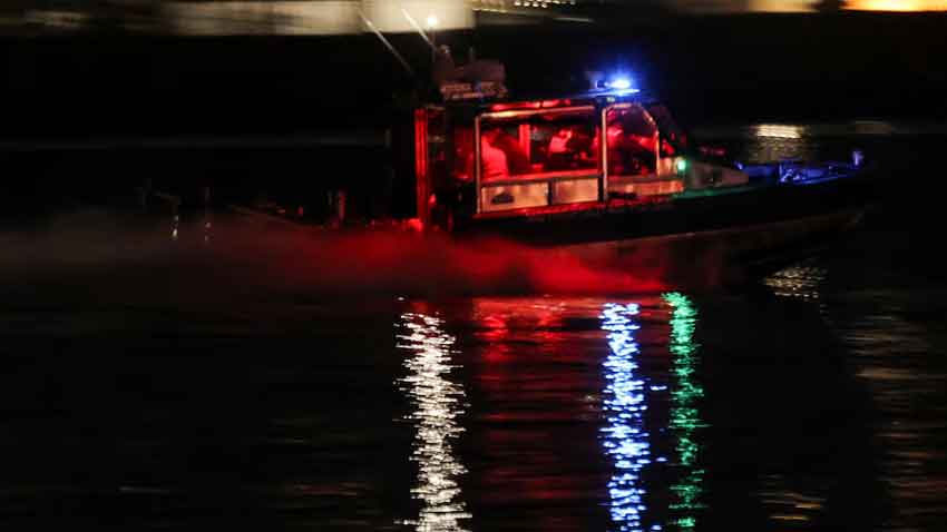 A search and rescue boat operates along the Potomac River near the site of the crash