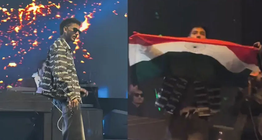 Talha Anjum on stage holding an Indian flag at a concert.
