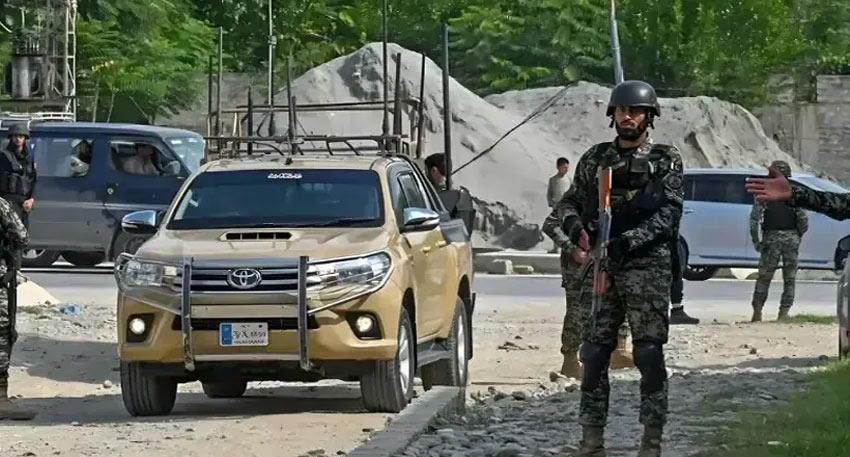 Armed security personnel stand guard near a tan pickup truck during an operation in North Waziristan.