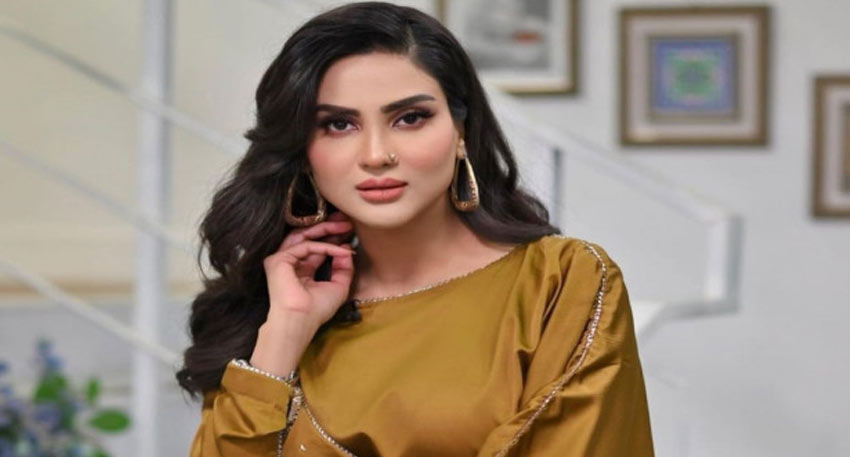 Pakistani actress Fiza Ali posing in a mustard-colored dress with gold earrings and dark wavy hair.