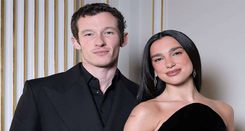 Singer Dua Lipa and actor Callum Turner posing together at an event in black formal attire.