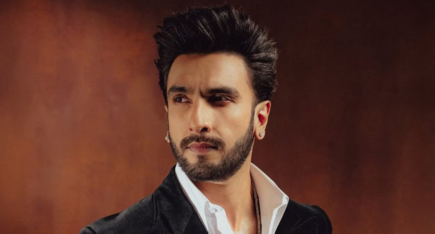Portrait of actor Ranveer Singh looking sideways, wearing a black velvet blazer and white shirt.