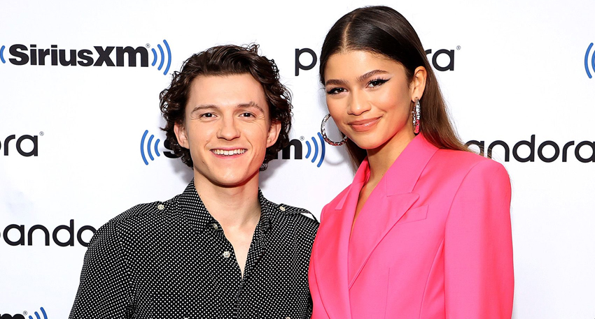 Tom Holland and Zendaya smiling together at a SiriusXM event.