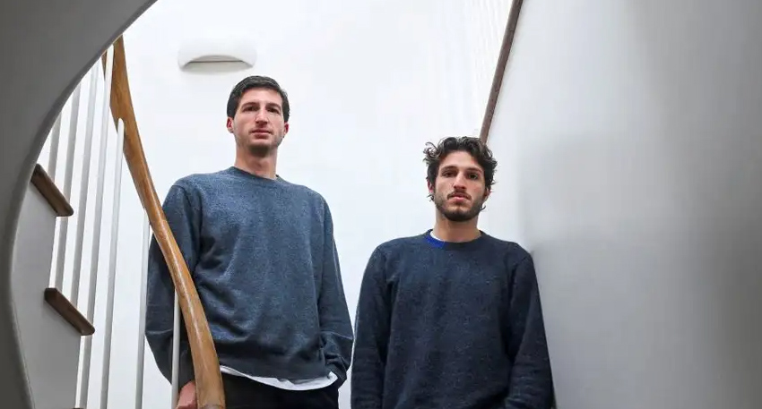 Imran Khan's sons, Sulaiman and Kasim, standing on a staircase.