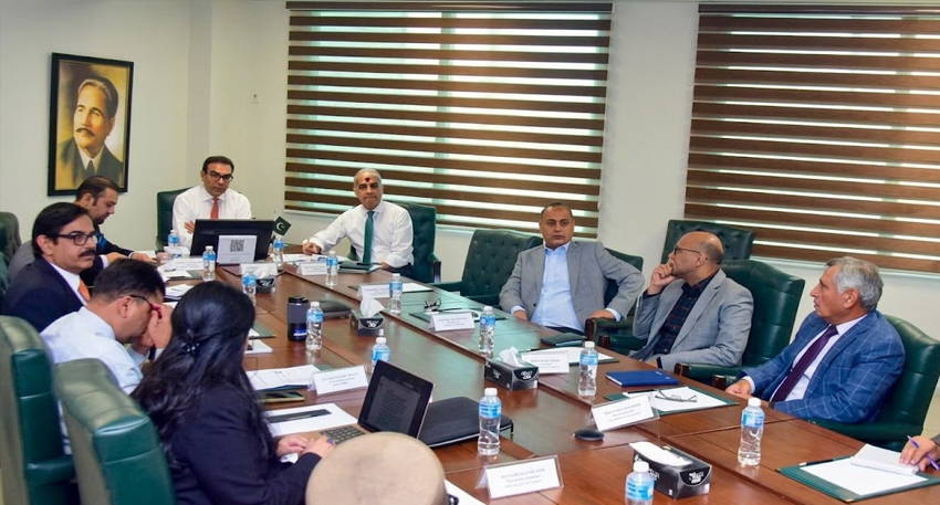 Officials discuss Karachi and Lahore airport outsourcing plan at a conference table.