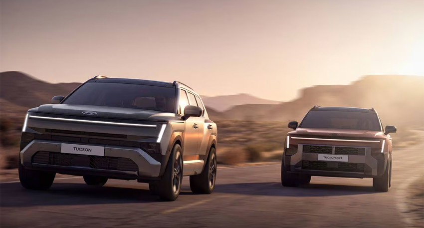 Two 2027 Hyundai Tucson SUVs driving on a desert road at sunset.