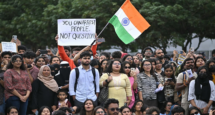 Protesters with an Indian flag and placards at a Delhi rally.