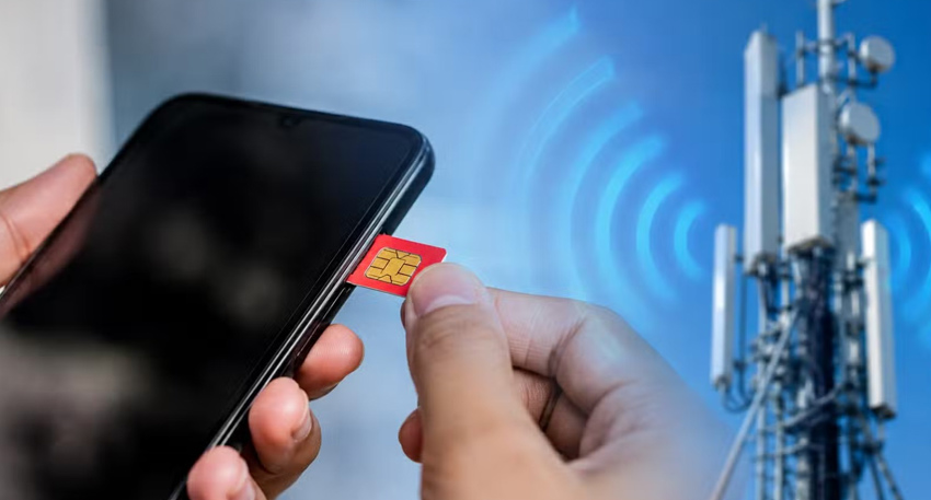A hand inserting a red SIM card into a smartphone next to a cellular tower.