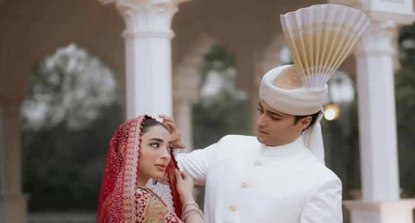 Junaid Safdar, son of Maryam Nawaz, adjusts his bride Shanzeh Ali Rohail's veil at their wedding.