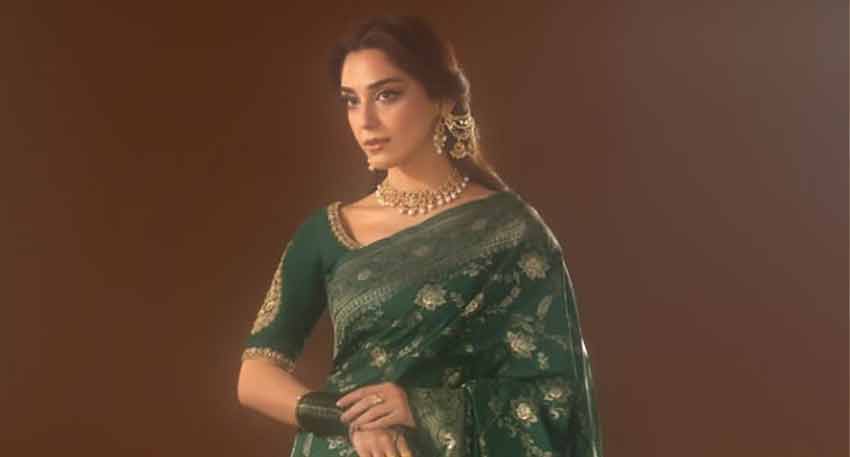 Pakistani actress Maya Ali in a deep emerald green banarsi silk saree with gold embroidery, a choker, and earrings.