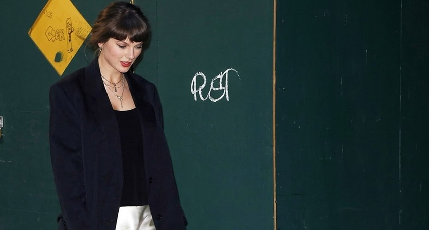 Taylor Swift in a black blazer and white satin skirt on a NYC street