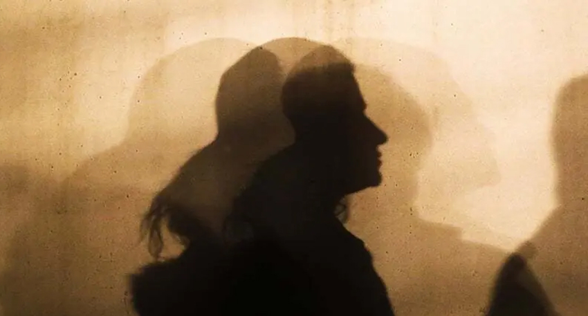 Silhouette of people cast on a wall as shadows.