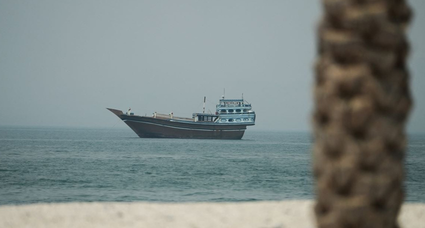 Traditional dhow ship sailing in the calm waters of the Strait of Hormuz.