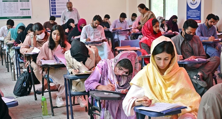 Students sitting at desks in an examination hall taking the MDCAT exam.