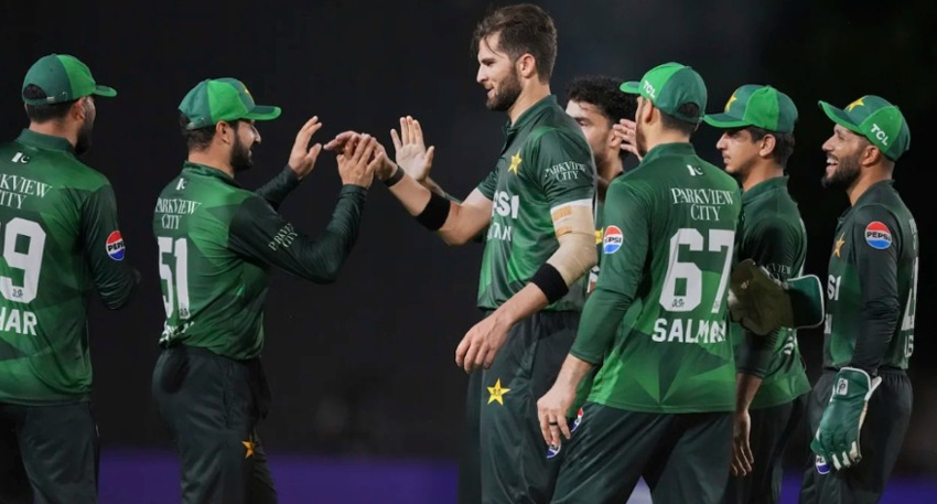 Pakistan men's cricket team players in green jerseys high-fiving and celebrating on the field.