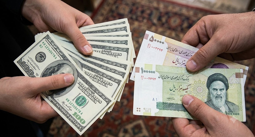 Hands holding fans of US Dollars and Iranian Rial banknotes over a patterned rug.-