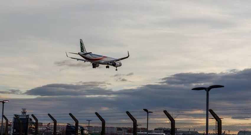 A Middle East Airlines Airbus A321neo aircraft landing at an airport with a cloudy sky backdrop.