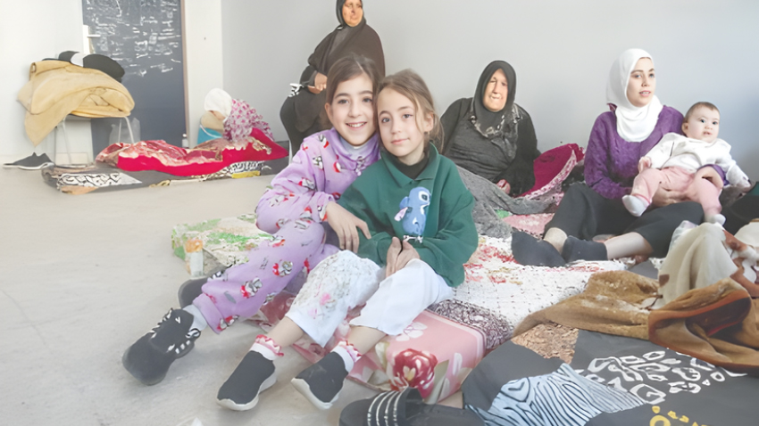Women and children seek refuge in a classroom at a school transformed into a shelter. File photo