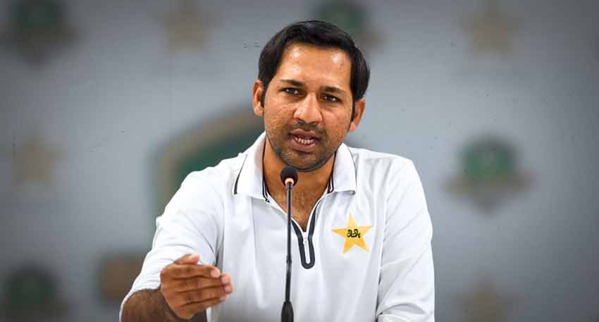 Sarfaraz Ahmed speaking at a press conference in a Pakistan cricket uniform.