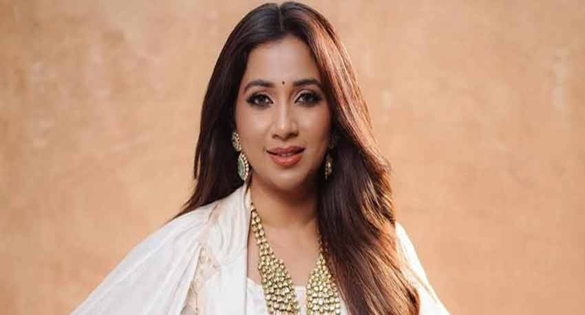 Shreya Ghoshal posing for a picture in white dress