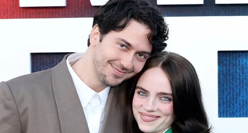Billie Eilish and Nat Wolff smiling closely together at the 