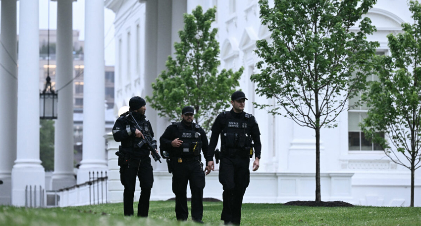 Security personnel stand guard outside the White House following a deadly shooting incident in Washington, D.C.