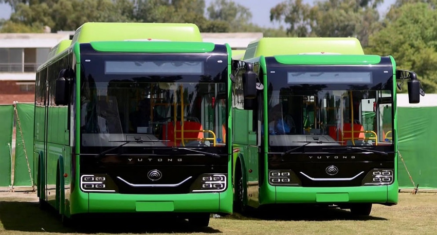 Two green Yutong electric buses parked side-by-side in Punjab, Pakistan.