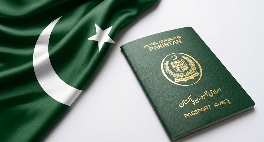 Close-up of a green Pakistani passport placed next to a waving flag of Pakistan on a white background.