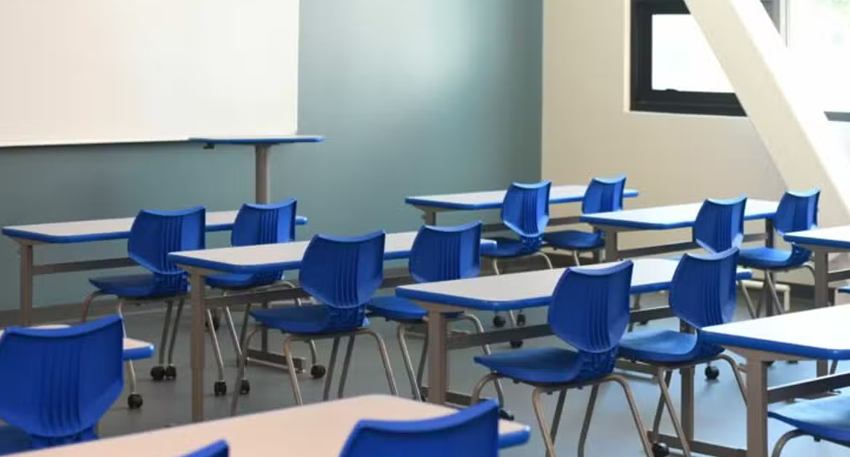 Blue chairs and grey desks in an empty, modern classroom.