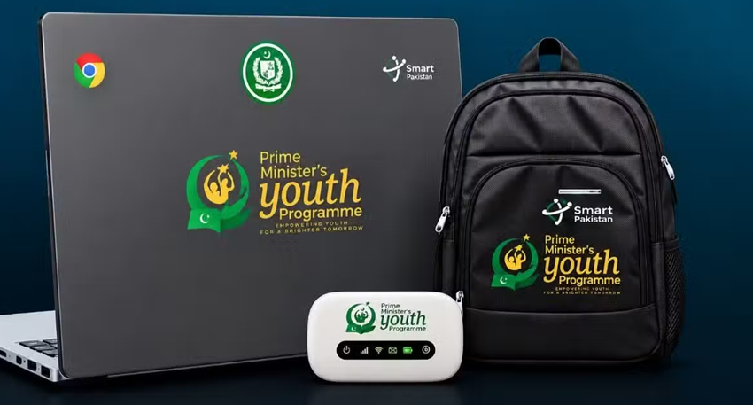 A Chromebook laptop, white EVDO internet device, and black backpack branded with Pakistan's Prime Minister Youth Programme logo.