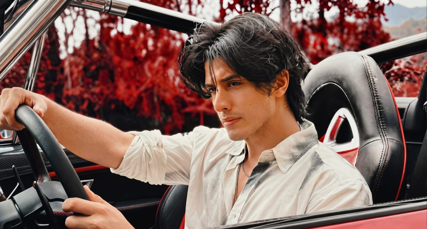 Danyal Zafar in a red convertible car.