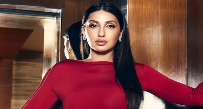 Nora Fatehi in a sleek red dress posing confidently.