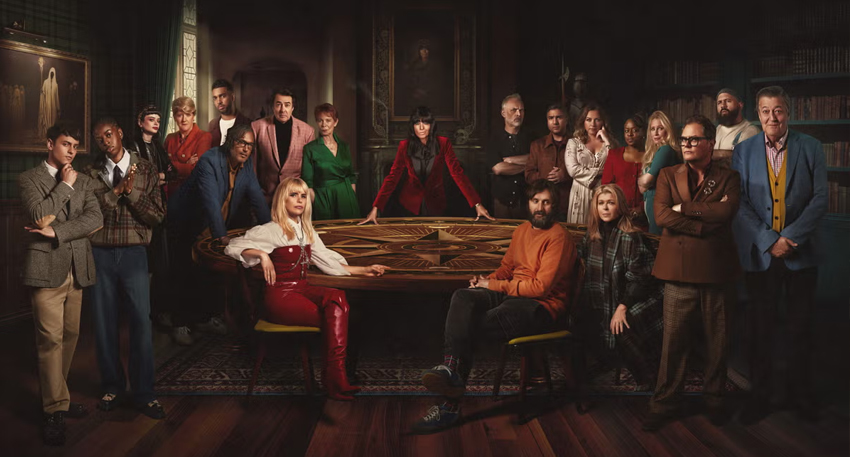 Claudia Winkleman and the cast of Celebrity Traitors gather around a dark round table.