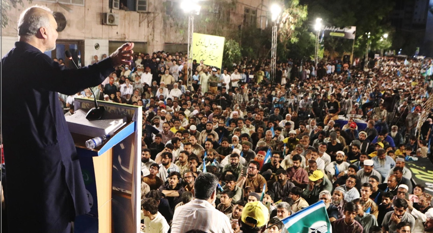 Hafiz Naeem ur Rehman addresses a large crowd from a podium during a Jamaat-e-Islami rally in Karachi.
