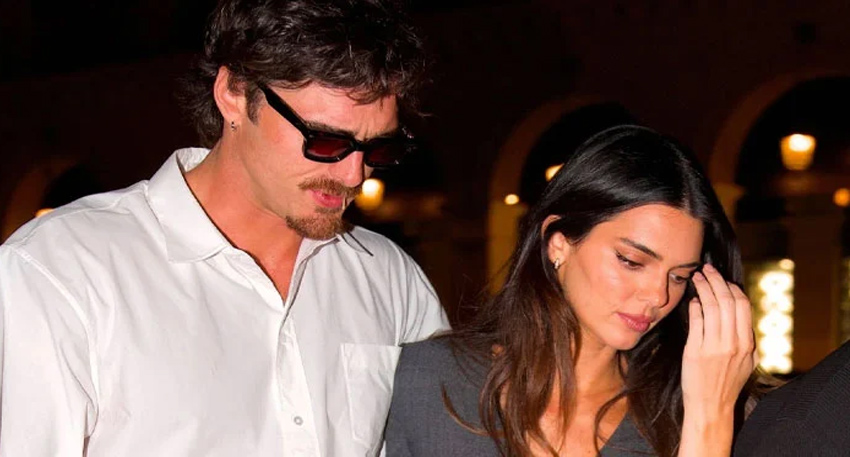 Jacob Elordi and Kendall Jenner walking together outdoors at night during Paris Fashion Week.